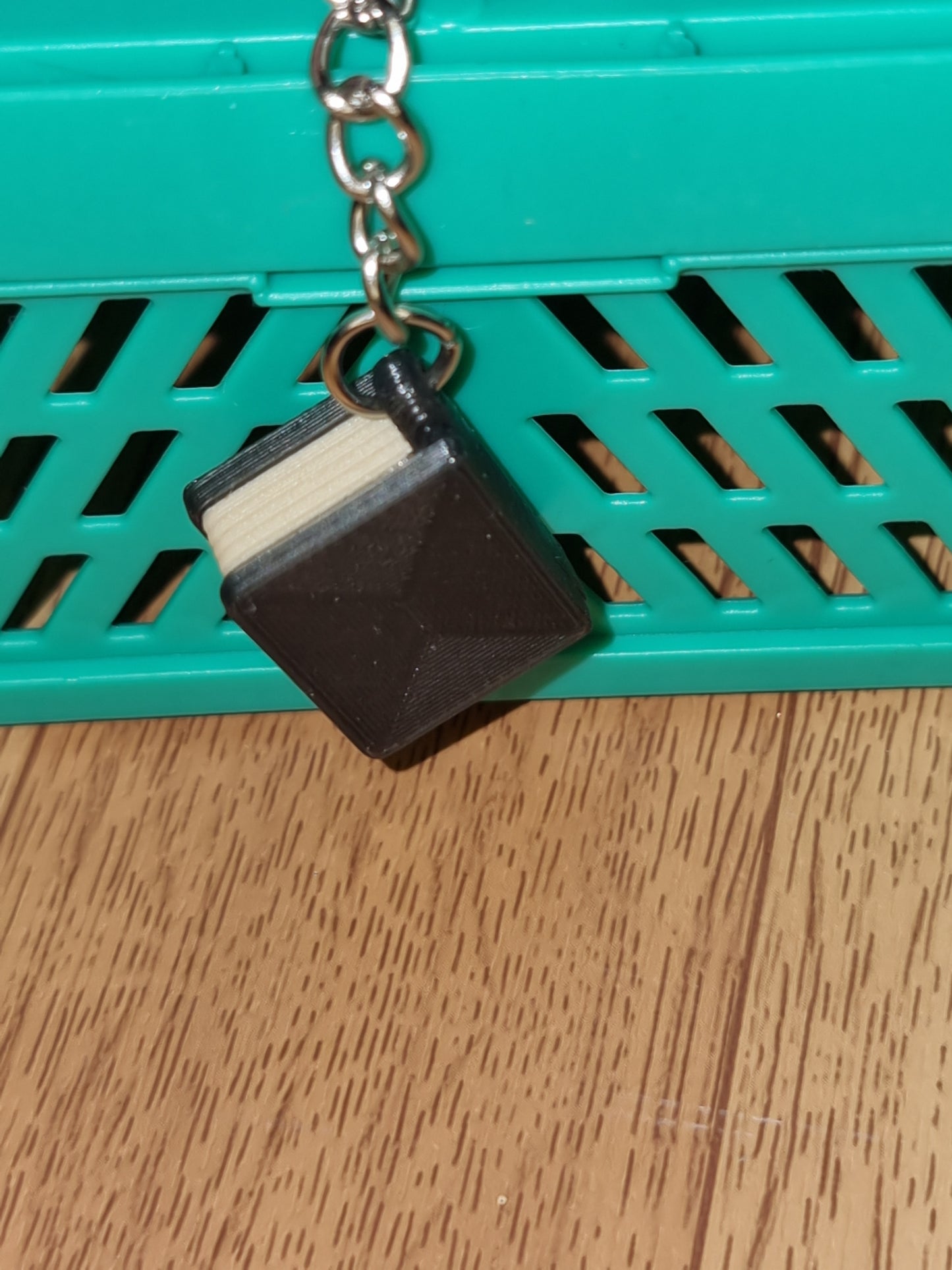 A unique 3D printed book keyrings with intricate details, perfect for book lovers.