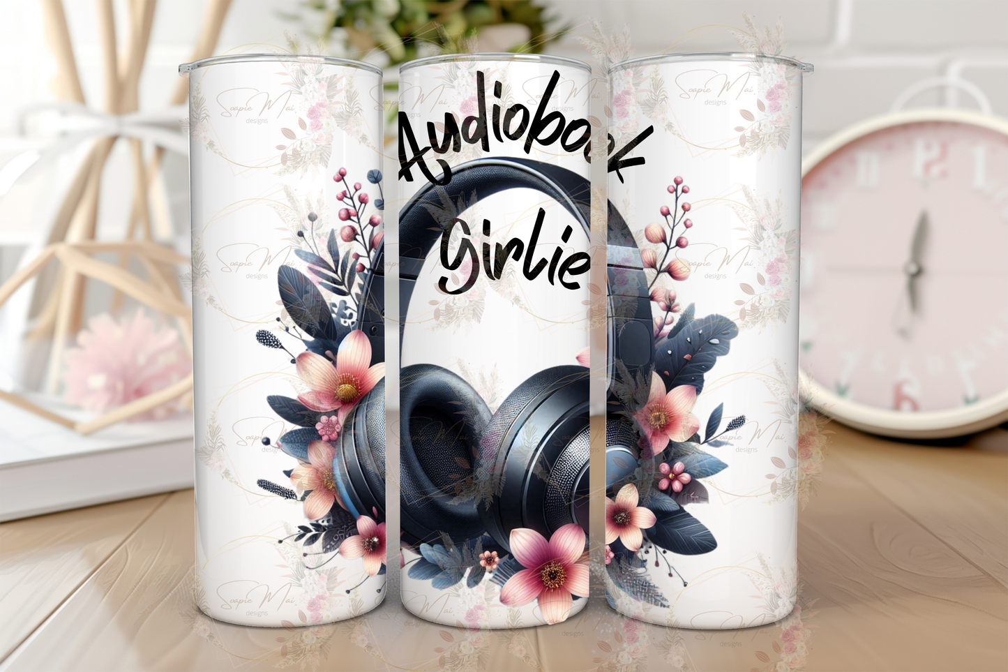 Stainless steel travel tumbler with "Audiobook Girlie" text and headphones with floral accents illustration, perfect for hot or cold drinks.