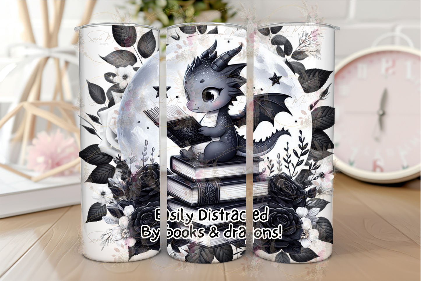 Stainless steel sublimation tumbler with an 'Easily Distracted by Books & Dragons' design, showing a black and white dragon reading on books with a floral moonlit background, ideal for hot or cold drinks.