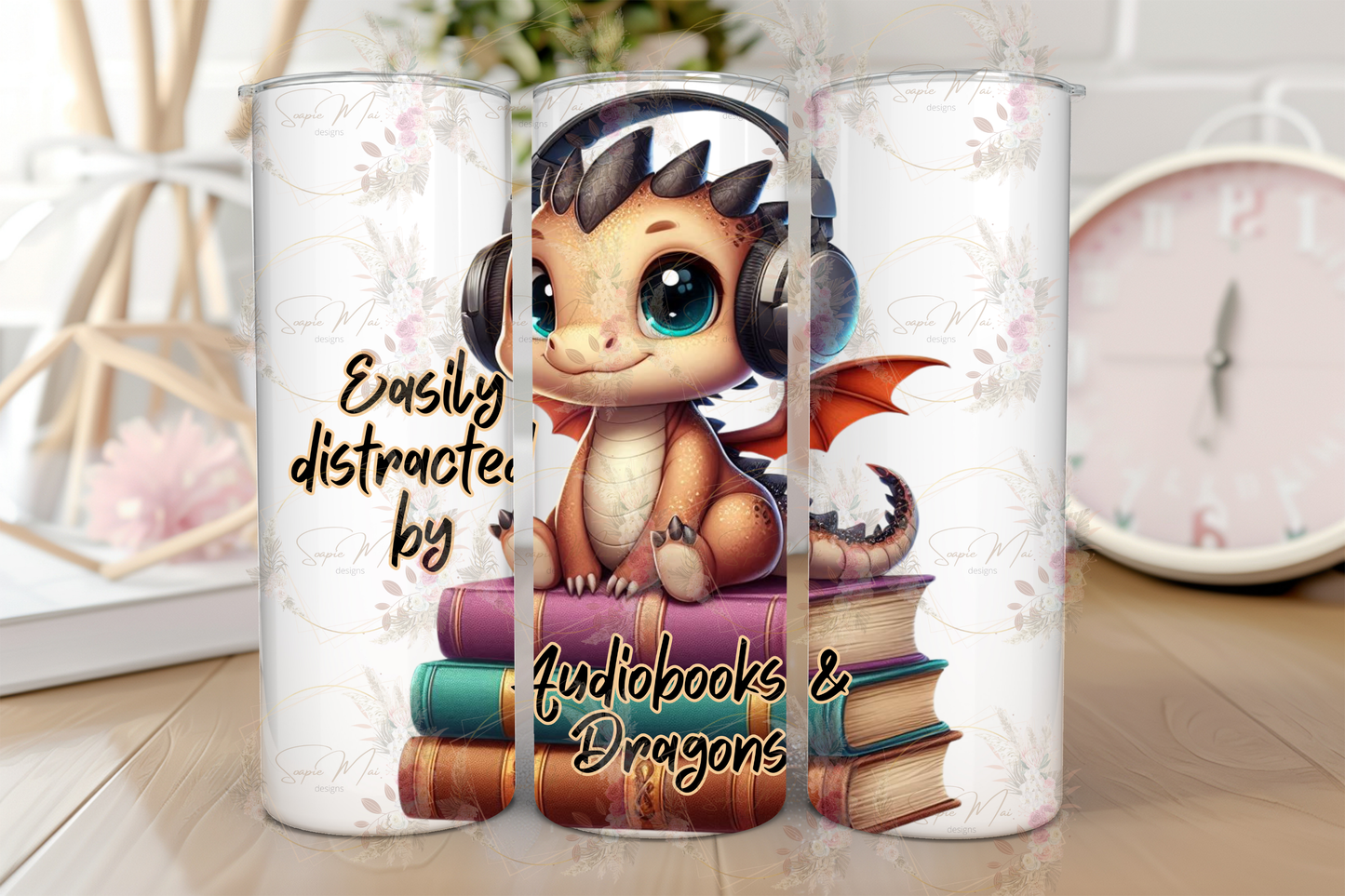 Stainless steel travel tumbler with "Easily Distracted by Audiobooks and Dragons" text and a whimsical dragon illustration, perfect for hot or cold drinks.