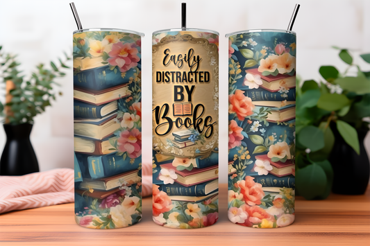 Stainless steel travel tumbler with "Easily Distracted by Books" text and a book stack with floral accents illustration, perfect for hot or cold drinks.