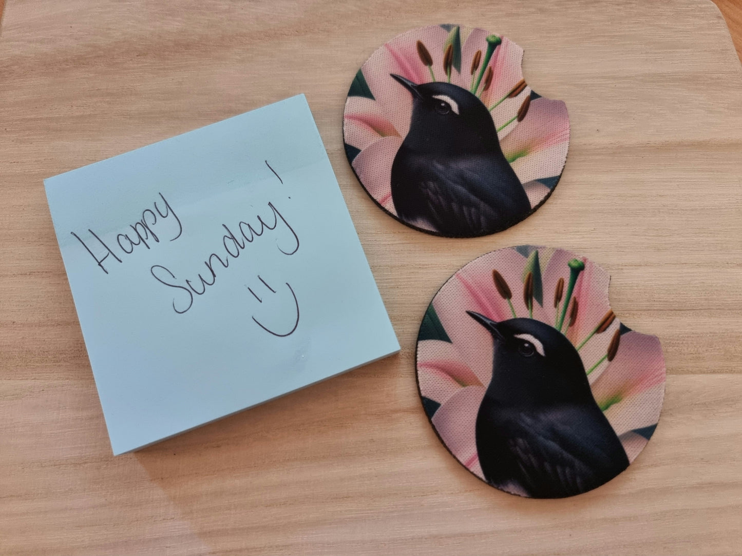 Pair of absorbent car coasters featuring a sweet Willie Wagtail and pink lily design, protecting your vehicle's cup holders.