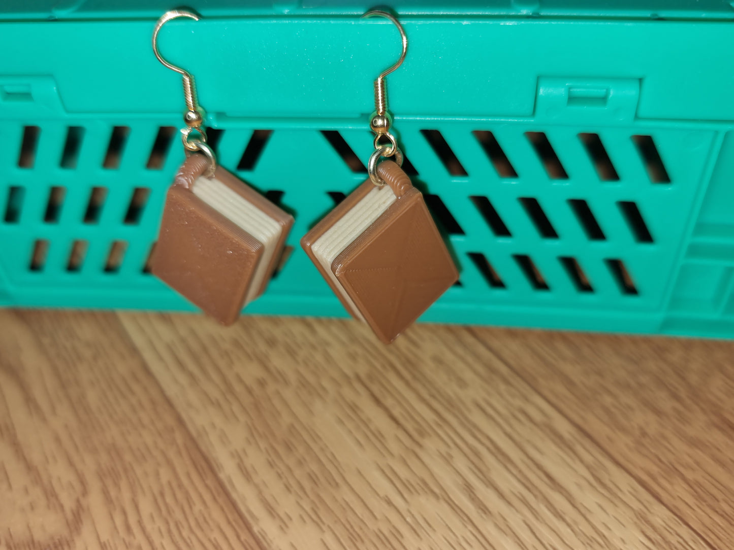 Pair of unique 3D printed book earrings with intricate details, perfect for book lovers.