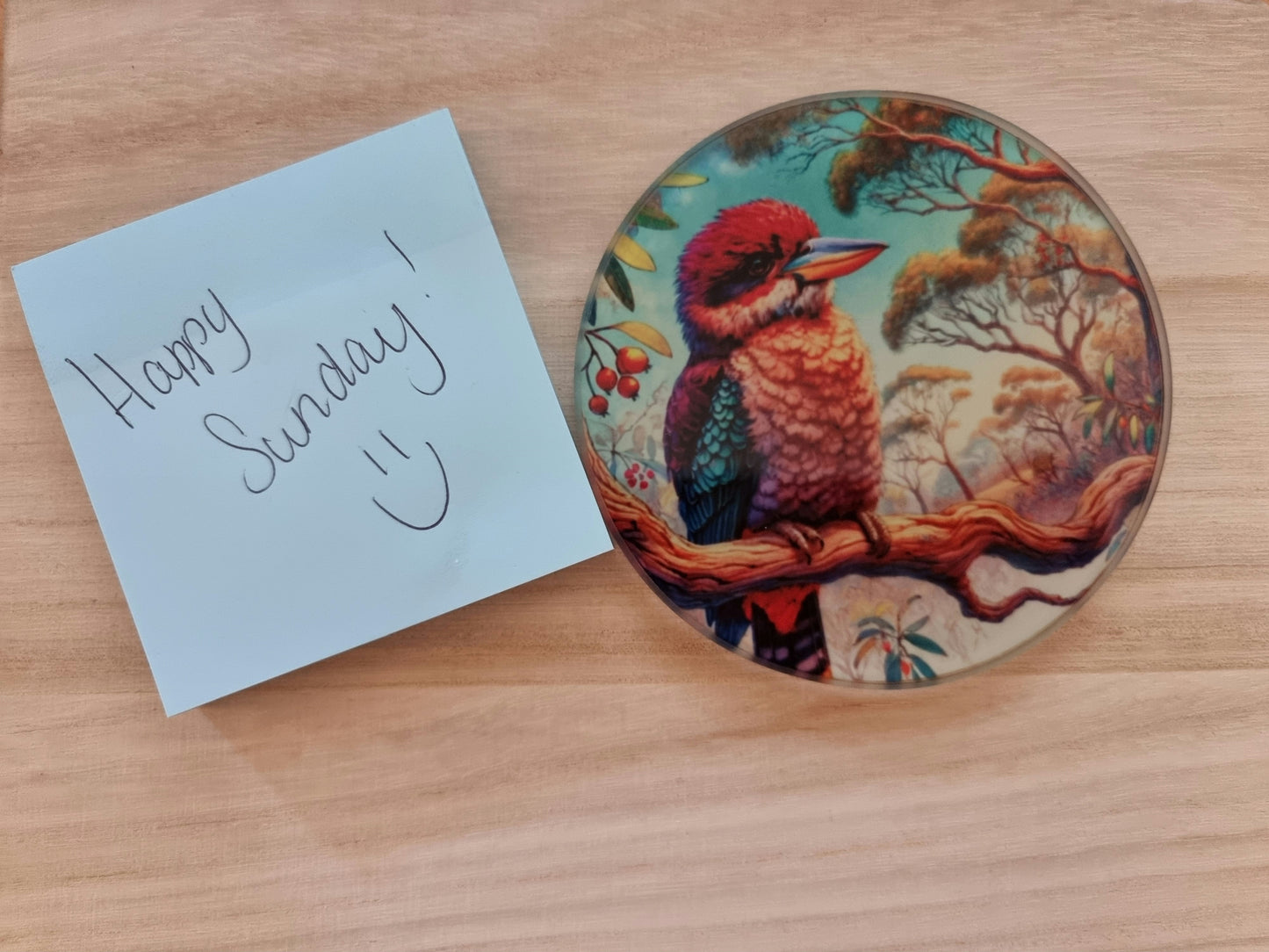 Round glass coaster with a detailed Kookaburra in a tree sublimation print, protecting surfaces in style.